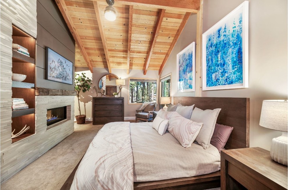 Diseño de dormitorio principal minimalista de tamaño medio con paredes beige, moqueta, chimenea de doble cara, marco de chimenea de piedra y suelo beige