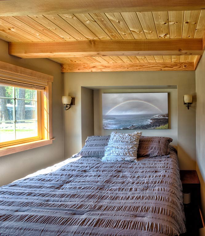 Cette image montre une petite chambre parentale craftsman avec un mur gris, un sol en bois brun et aucune cheminée.