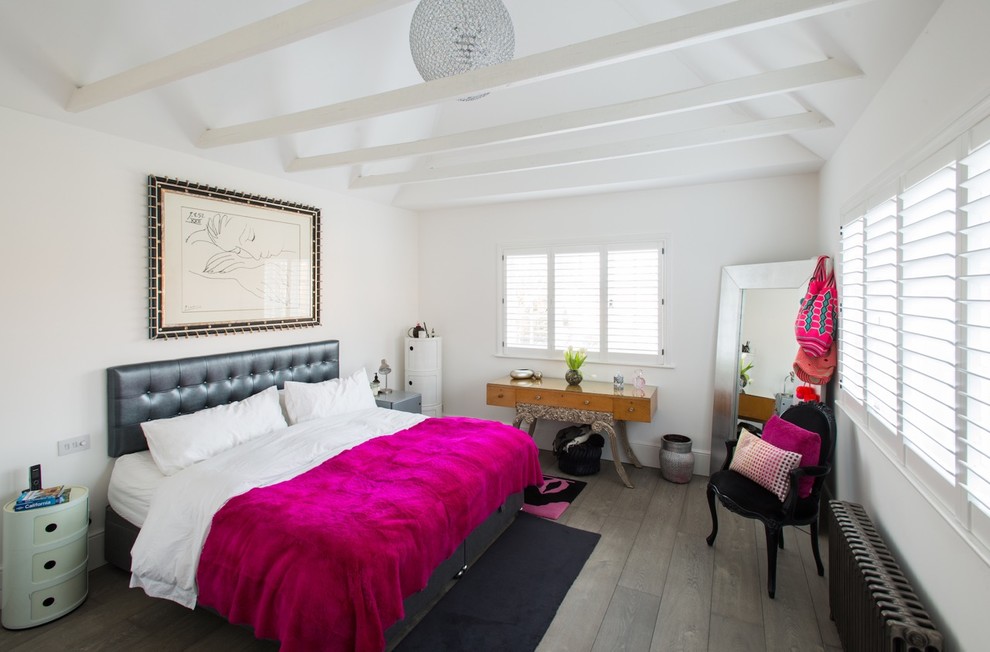 Mittelgroßes Modernes Schlafzimmer ohne Kamin mit weißer Wandfarbe und braunem Boden in London