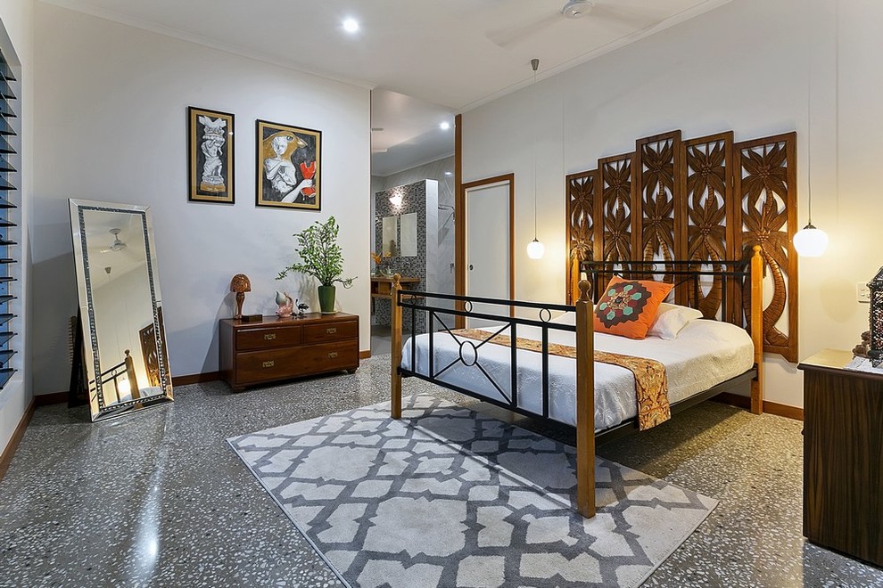 Idee per una camera da letto tropicale di medie dimensioni con pareti bianche, pavimento in cemento e pavimento grigio