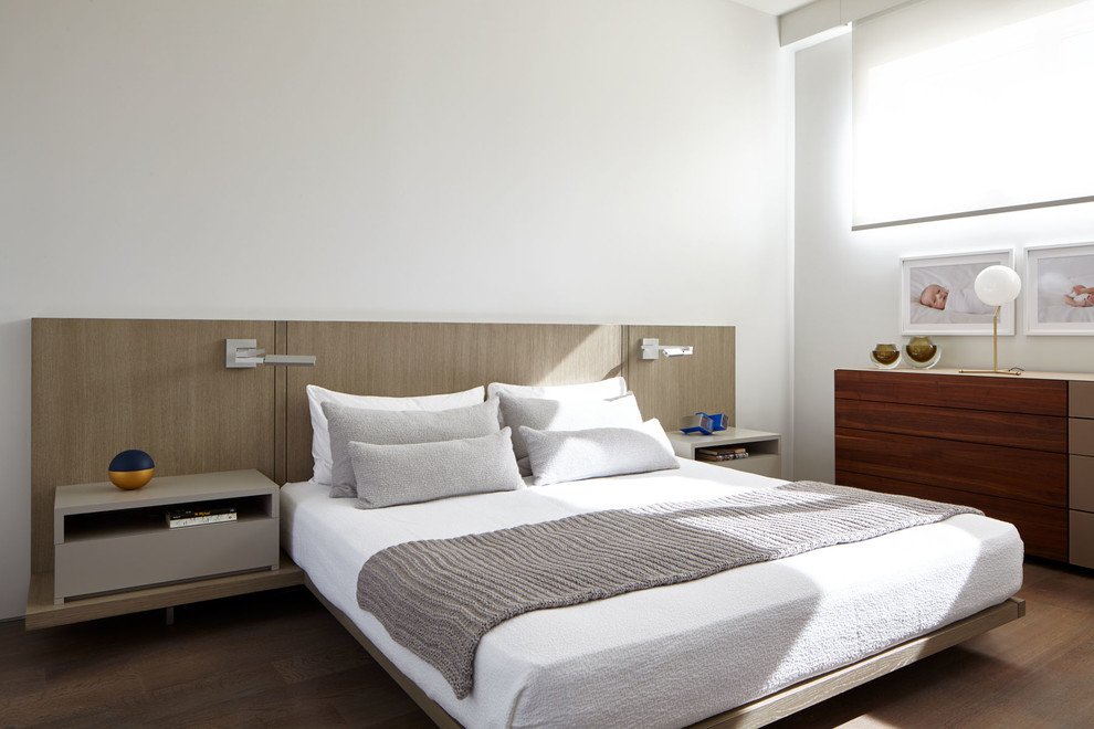 Mittelgroßes Modernes Hauptschlafzimmer mit weißer Wandfarbe, braunem Holzboden und braunem Boden in New York