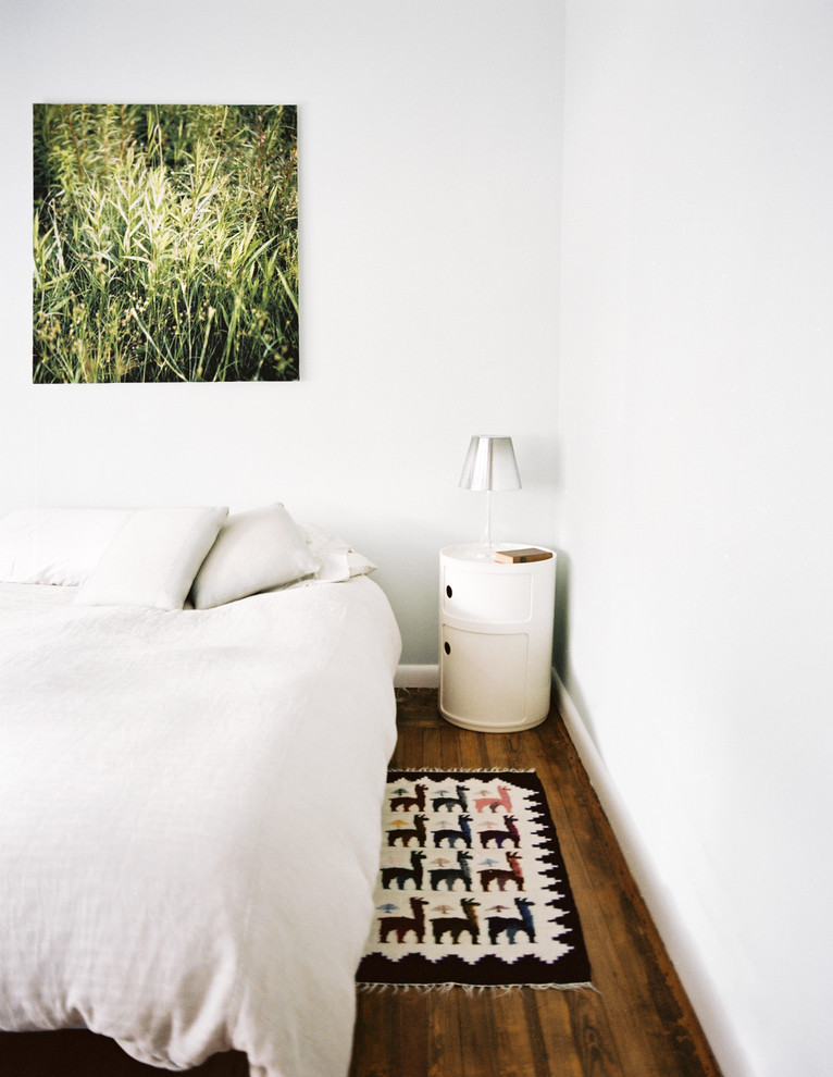 Modelo de dormitorio principal moderno de tamaño medio sin chimenea con paredes blancas y suelo de madera en tonos medios