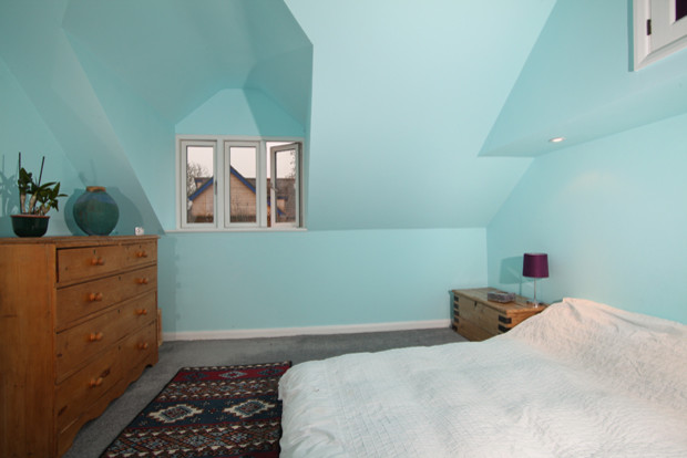 Cette image montre une chambre rustique de taille moyenne avec un mur bleu et aucune cheminée.