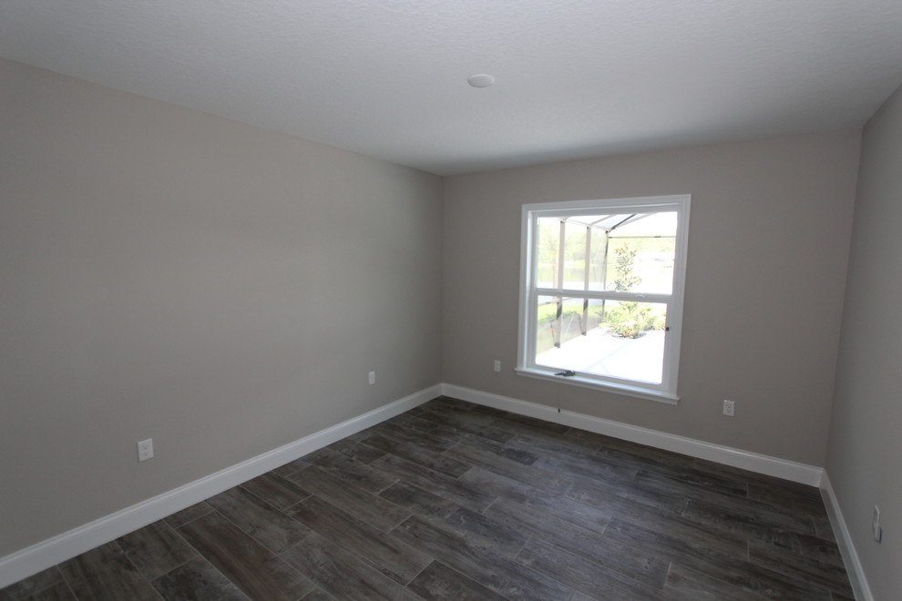 Imagen de habitación de invitados tradicional renovada de tamaño medio con paredes beige, suelo de baldosas de porcelana y suelo gris