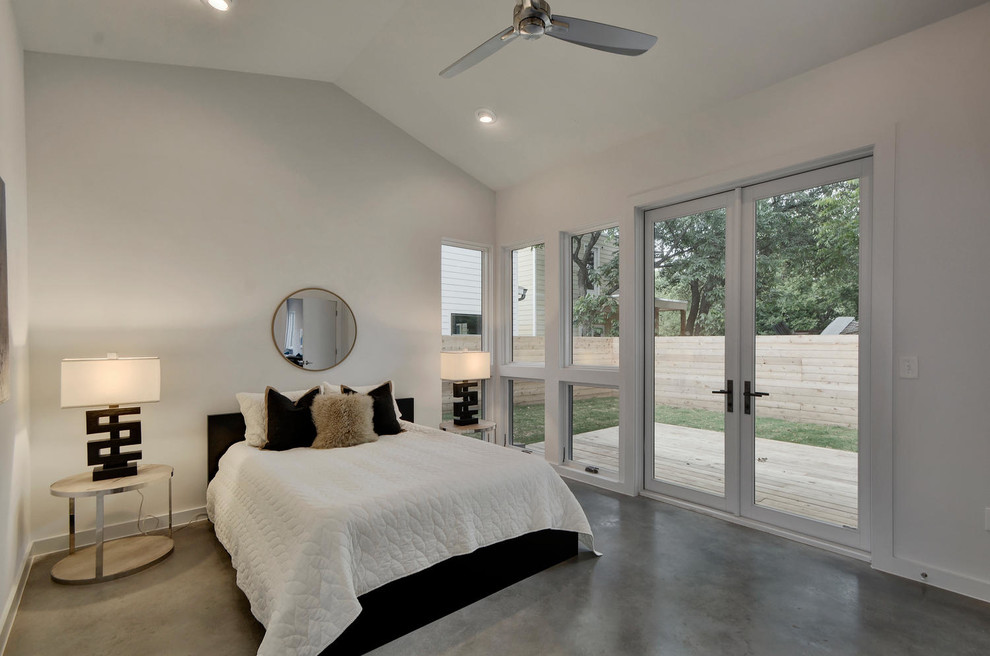 Cette photo montre une chambre parentale nature de taille moyenne avec un mur blanc, sol en béton ciré et un sol gris.