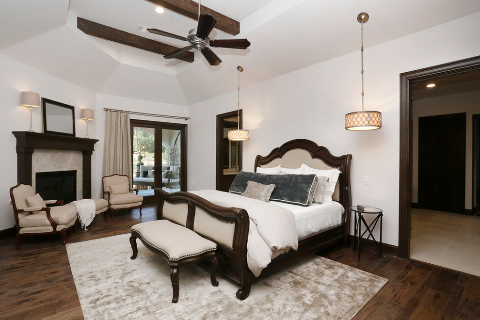 Example of a large transitional master medium tone wood floor bedroom design in Houston with white walls, a corner fireplace and a stone fireplace
