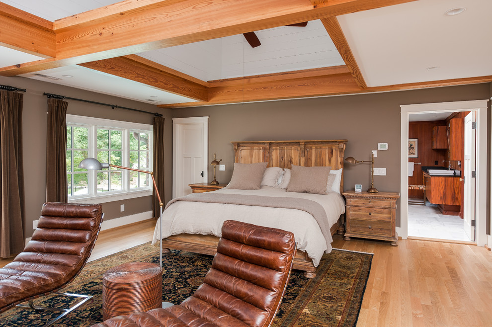 Imagen de dormitorio principal de estilo americano sin chimenea con paredes marrones y suelo de madera clara