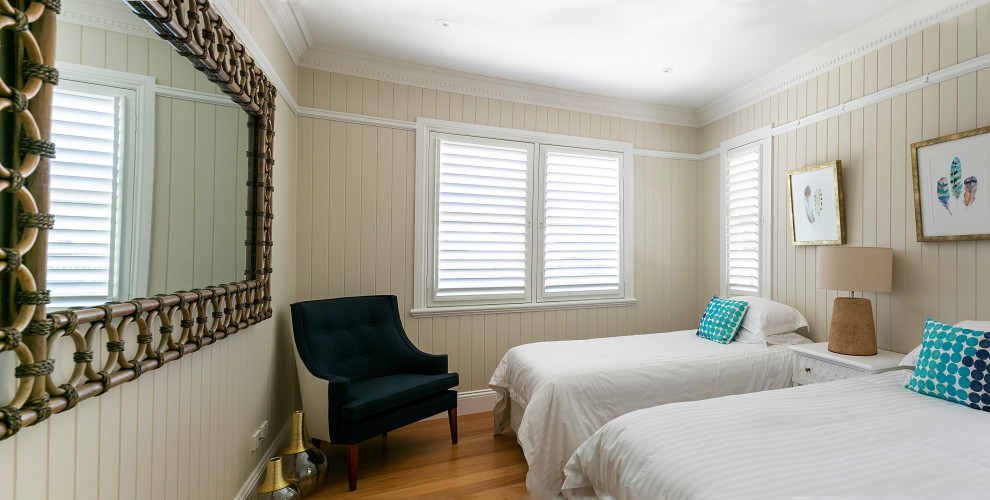 Mittelgroßes Eklektisches Gästezimmer mit weißer Wandfarbe, hellem Holzboden und orangem Boden in Brisbane
