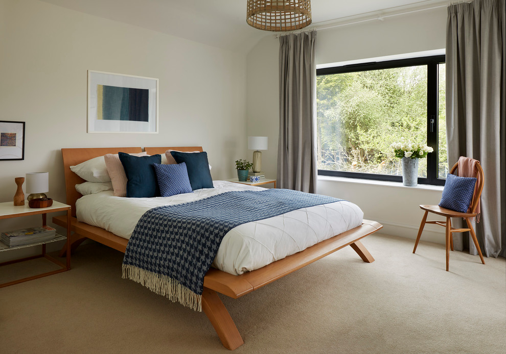 This is an example of a medium sized contemporary master bedroom in Wiltshire with white walls, carpet and no fireplace.