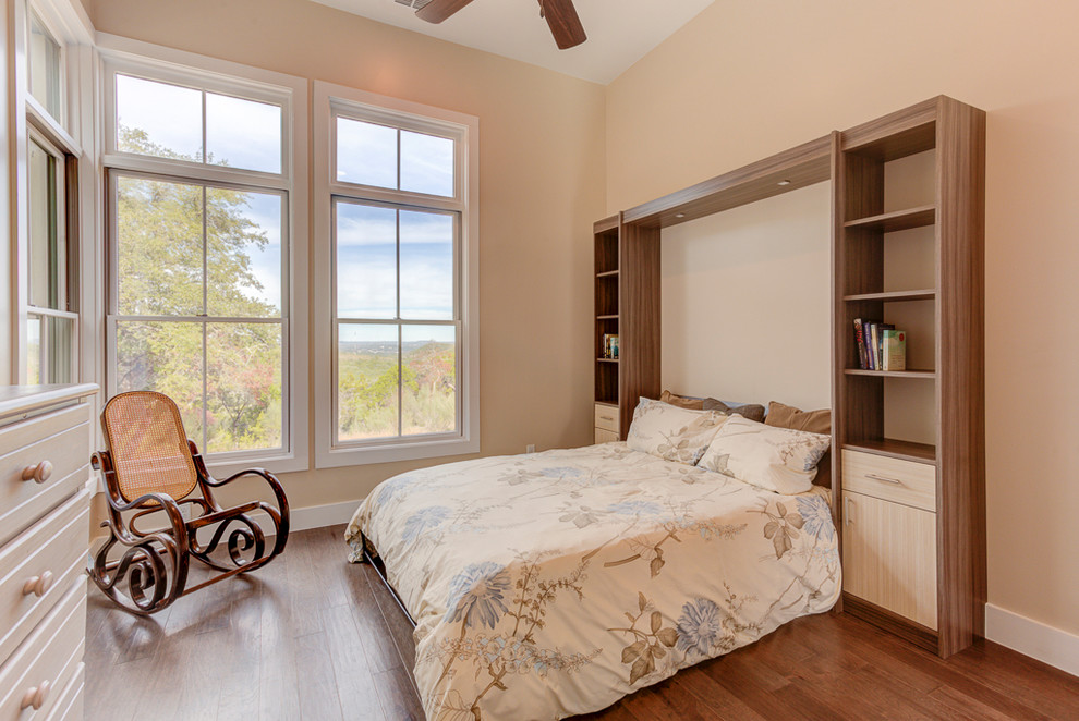 Mittelgroßes Country Gästezimmer ohne Kamin mit beiger Wandfarbe, braunem Holzboden und braunem Boden in Austin