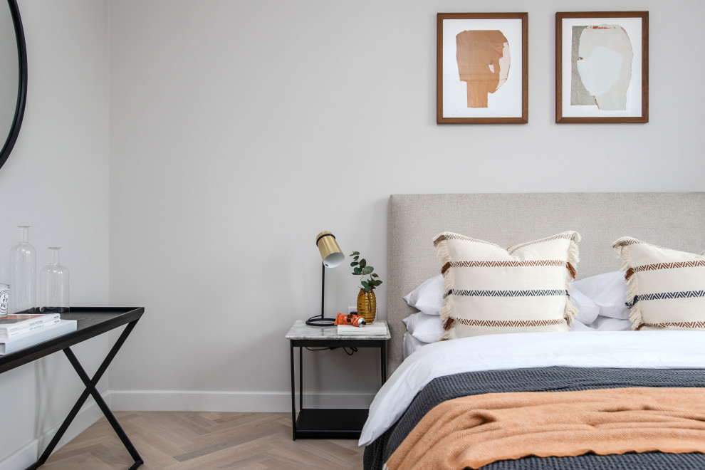 Photo of a small contemporary master bedroom in London with grey walls, light hardwood flooring and brown floors.