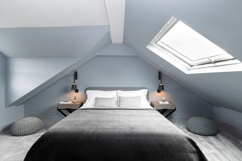 This is an example of a contemporary loft bedroom in London with grey walls, carpet and grey floors.
