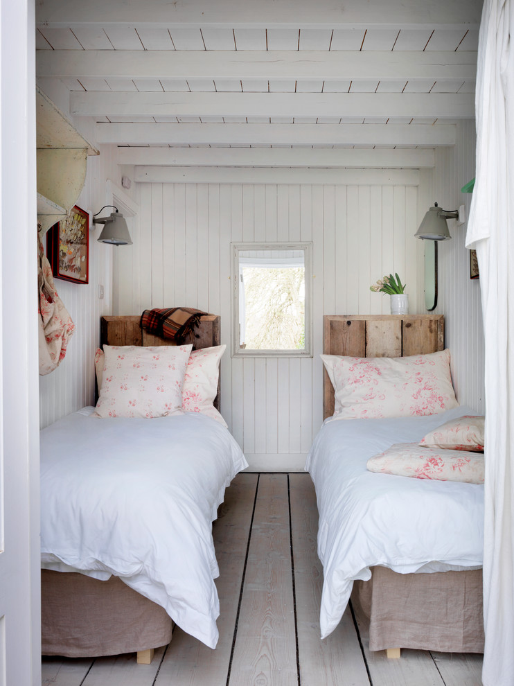 Bedroom - coastal light wood floor bedroom idea in London with white walls