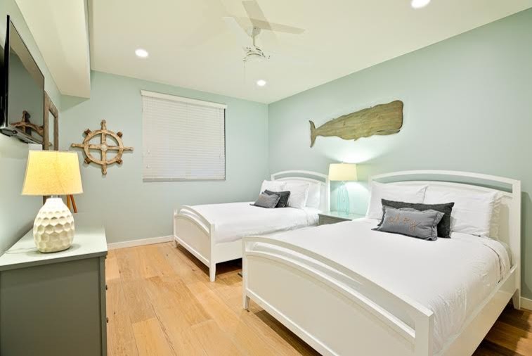 Imagen de dormitorio principal marinero pequeño con paredes beige y suelo de madera clara