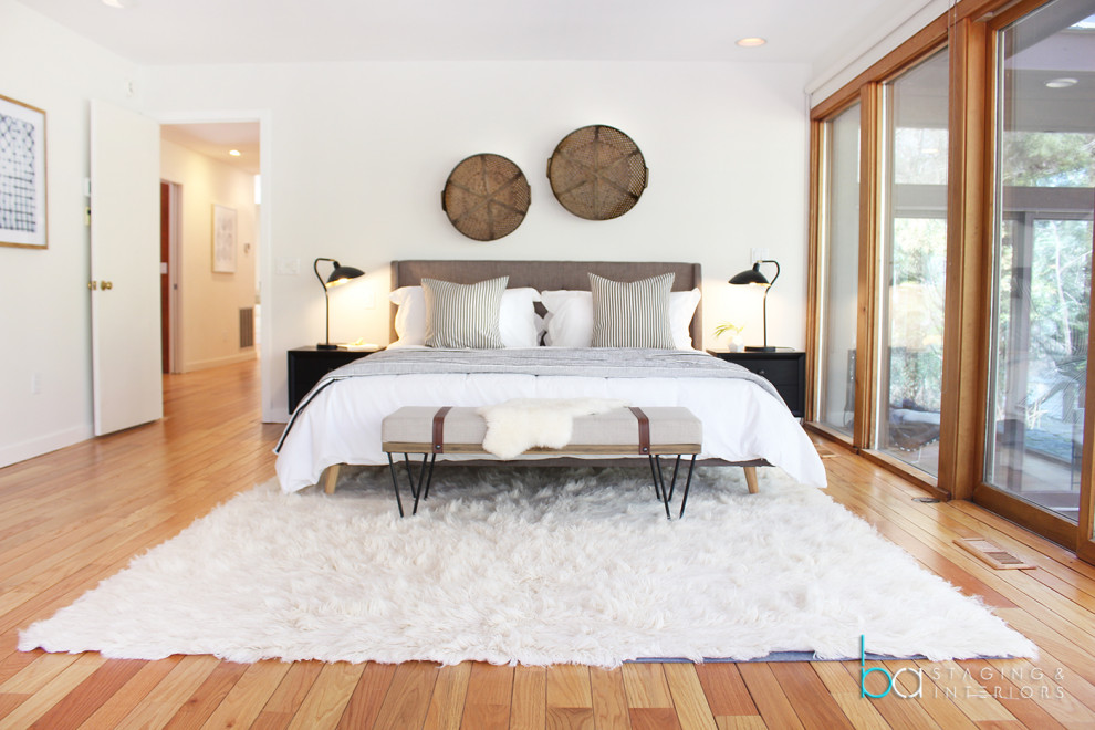 ニューヨークにある中くらいなコンテンポラリースタイルのおしゃれな主寝室 (白い壁、無垢フローリング、茶色い床)