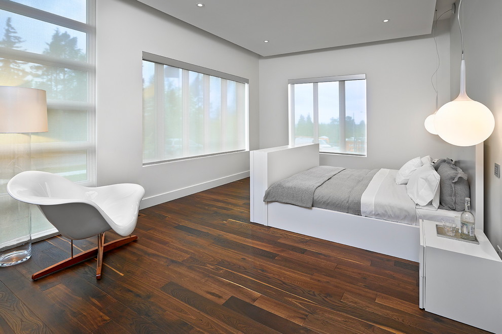 Großes Modernes Hauptschlafzimmer ohne Kamin mit weißer Wandfarbe und dunklem Holzboden in Edmonton