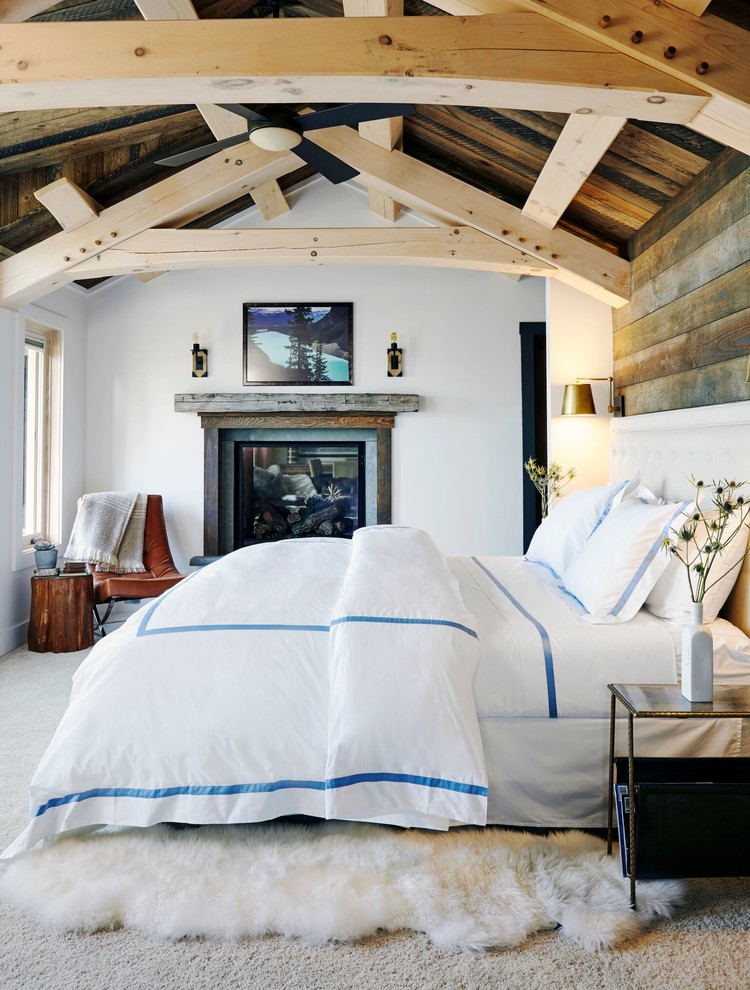 Идея дизайна: хозяйская спальня в стиле рустика с белыми стенами, ковровым покрытием, стандартным камином и серым полом
