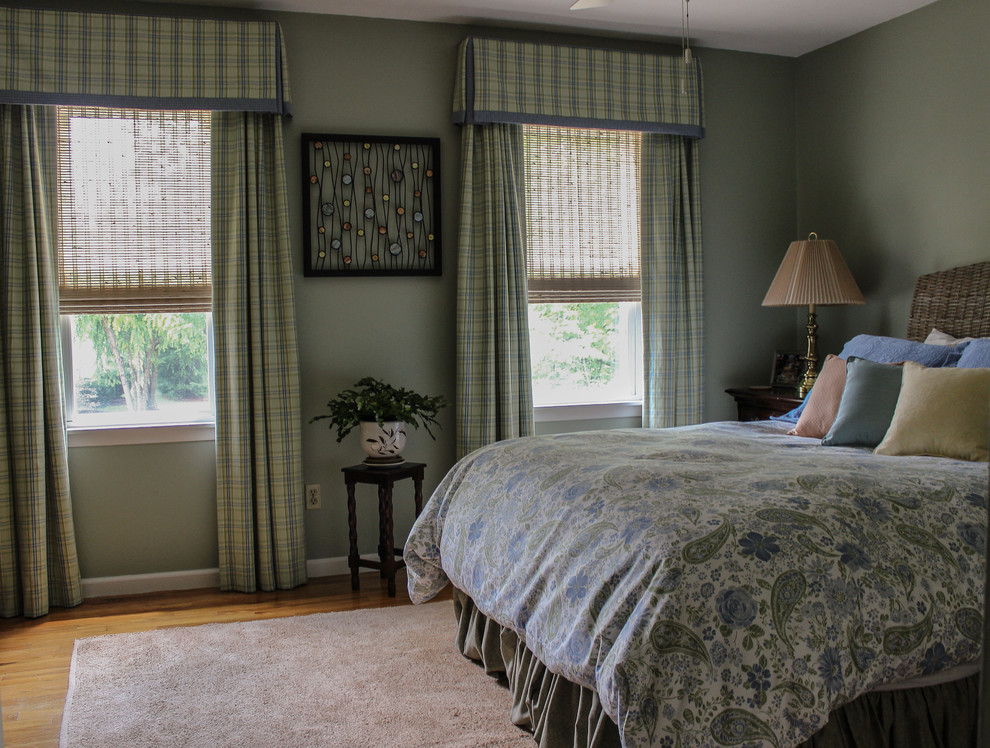 Modelo de habitación de invitados tradicional renovada de tamaño medio sin chimenea con paredes verdes y suelo de madera clara
