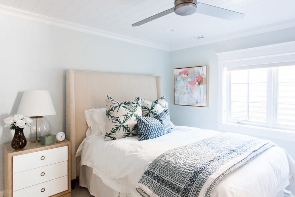 Exemple d'une chambre d'amis bord de mer de taille moyenne avec un mur bleu et un sol en bois brun.