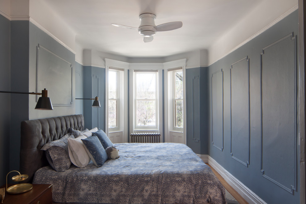 Cette photo montre une chambre chic avec un mur bleu, un sol en bois brun et un sol marron.