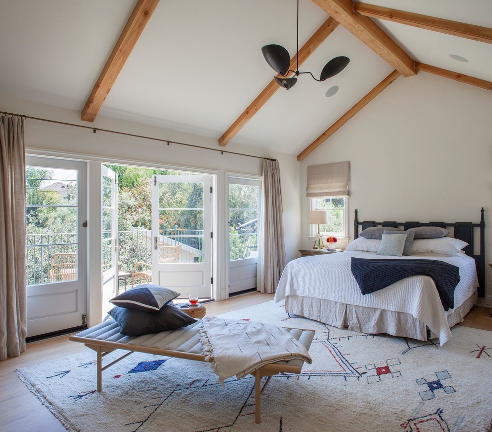 Design ideas for a medium sized farmhouse master bedroom in Los Angeles with white walls and light hardwood flooring.