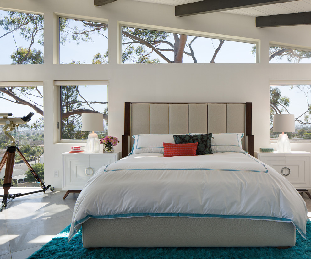 Contemporary bedroom in San Diego with white walls and grey floors.