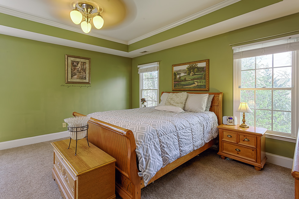 Réalisation d'une chambre tradition de taille moyenne avec un mur vert et un sol marron.