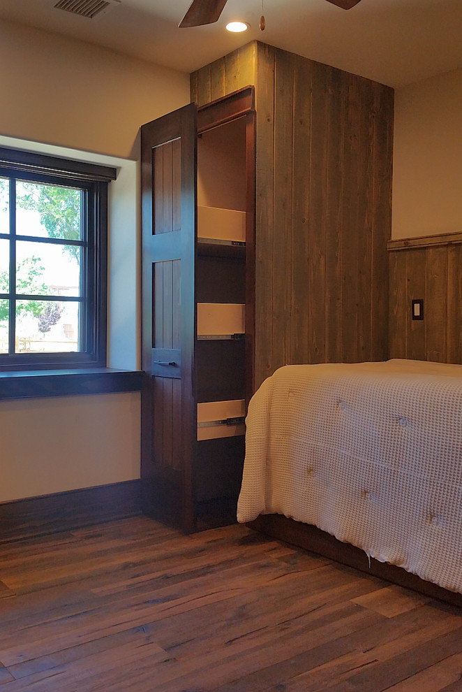 Modelo de habitación de invitados de estilo de casa de campo pequeña con paredes blancas, suelo de madera en tonos medios y suelo marrón