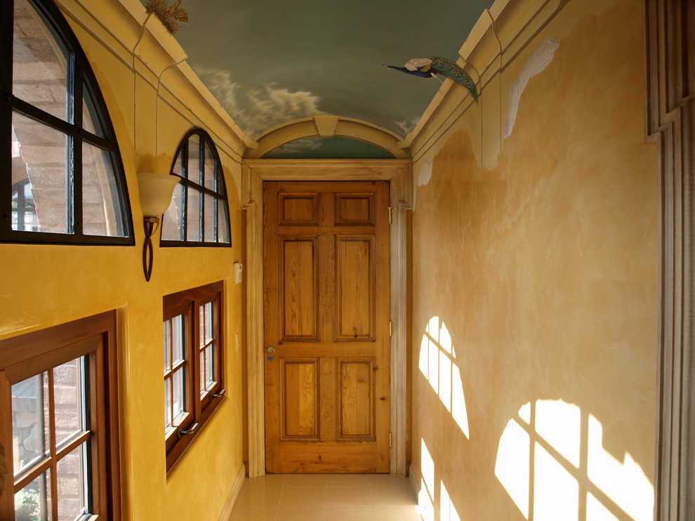 サンディエゴにある広い地中海スタイルのおしゃれな主寝室 (黄色い壁、大理石の床、両方向型暖炉、石材の暖炉まわり) のインテリア