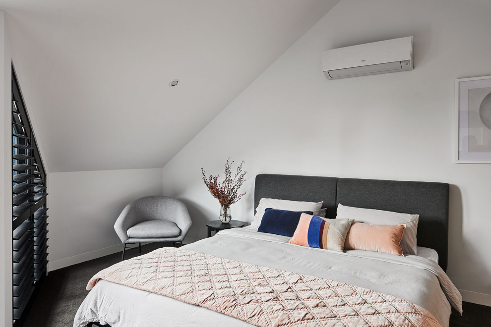 Modelo de dormitorio principal y abovedado actual pequeño con paredes blancas, moqueta y suelo gris