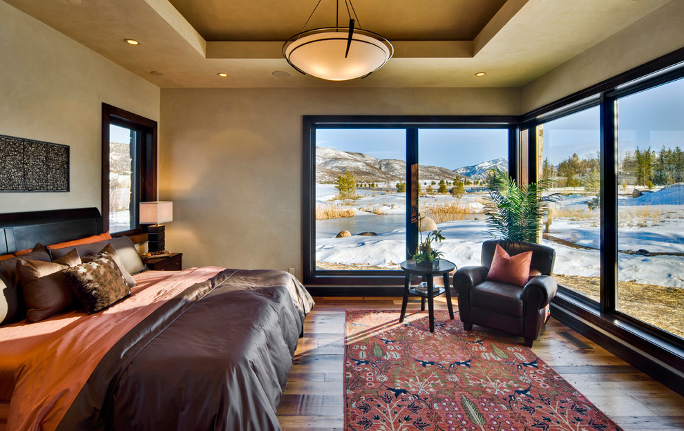 Inspiration for a rustic medium tone wood floor bedroom remodel in Denver with beige walls and no fireplace