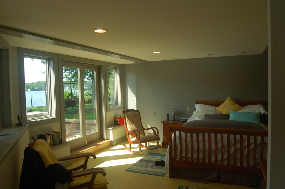 Modelo de dormitorio principal de estilo americano de tamaño medio con paredes verdes y suelo de cemento