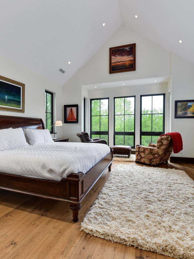 Photo of a large classic master bedroom in Other with white walls, medium hardwood flooring, no fireplace and brown floors.