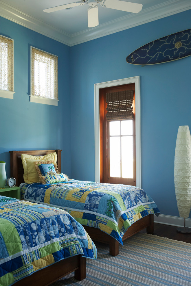 Aménagement d'une chambre d'amis bord de mer avec un mur bleu et parquet foncé.