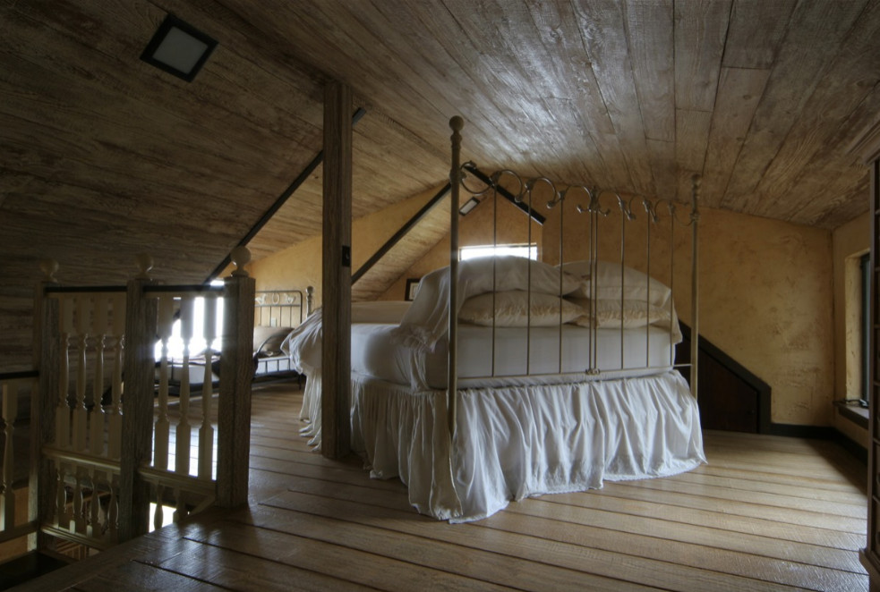 Immagine di una grande camera degli ospiti con pareti beige, pavimento in legno massello medio, nessun camino e pavimento marrone