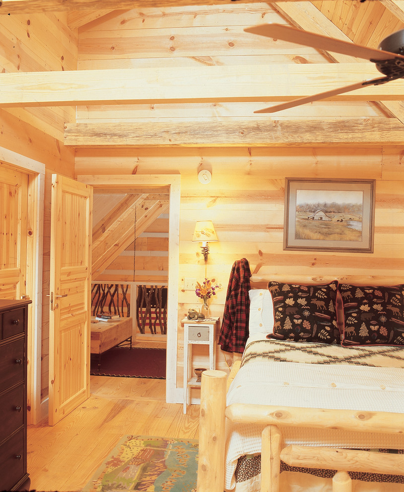 Ejemplo de dormitorio principal rústico de tamaño medio con paredes beige y suelo de madera clara
