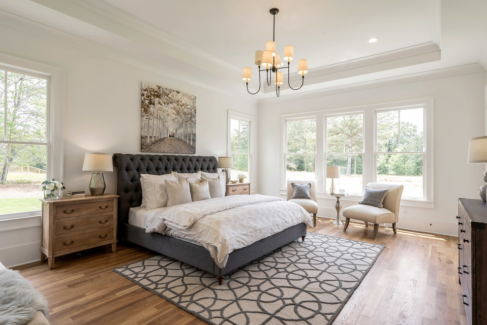 Landhaus Schlafzimmer mit weißer Wandfarbe, braunem Holzboden und braunem Boden in Atlanta