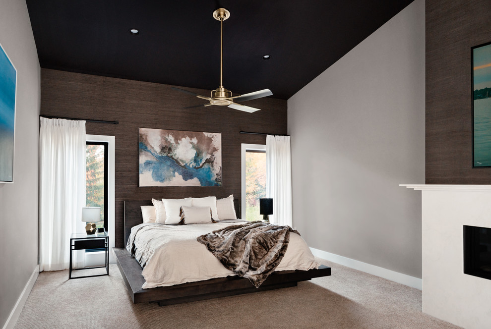 Идея дизайна: большая хозяйская спальня в стиле ретро с коричневыми стенами, ковровым покрытием, стандартным камином и бежевым полом