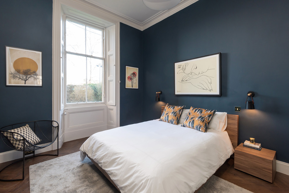 Contemporary grey and brown bedroom in Other with blue walls, dark hardwood flooring, no fireplace and brown floors.