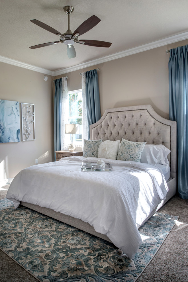 На фото: спальня в стиле неоклассика (современная классика) с бежевыми стенами, ковровым покрытием, бежевым полом и синими шторами