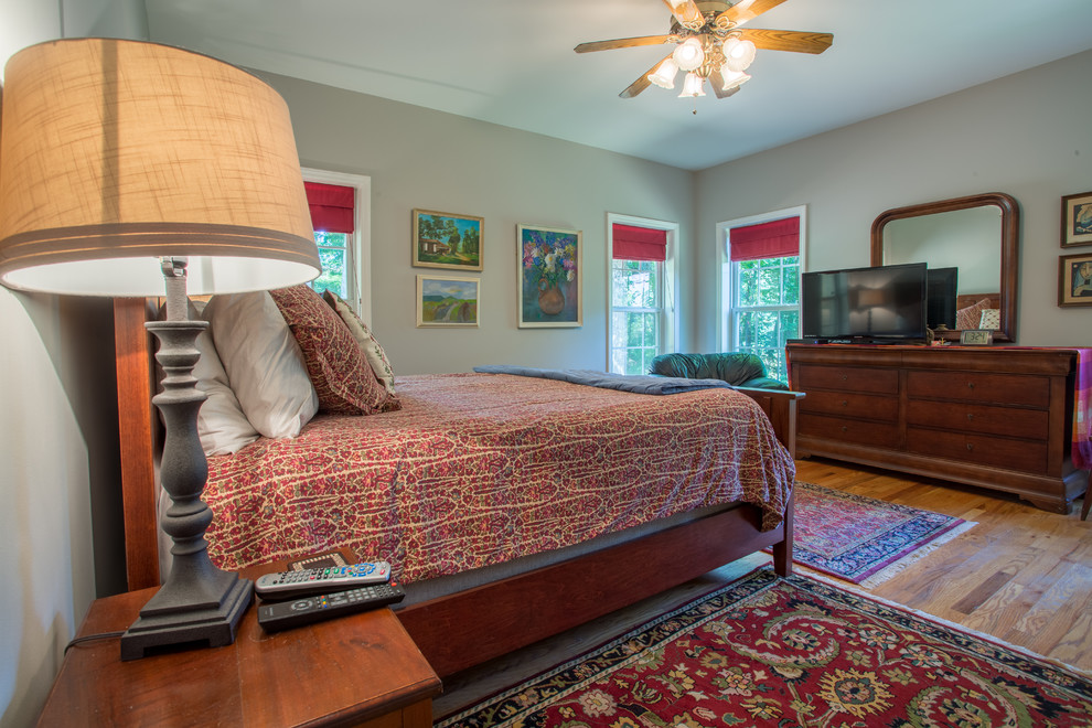 Modelo de dormitorio principal romántico de tamaño medio con paredes grises y suelo de madera en tonos medios