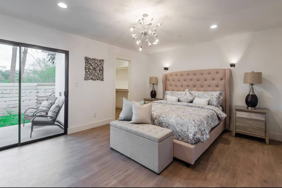 Großes Landhausstil Hauptschlafzimmer ohne Kamin mit weißer Wandfarbe, braunem Holzboden und braunem Boden in Los Angeles