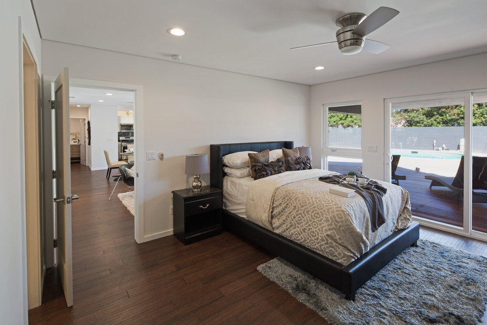 Aménagement d'une grande chambre d'amis contemporaine avec un mur blanc, parquet foncé, aucune cheminée et un sol marron.