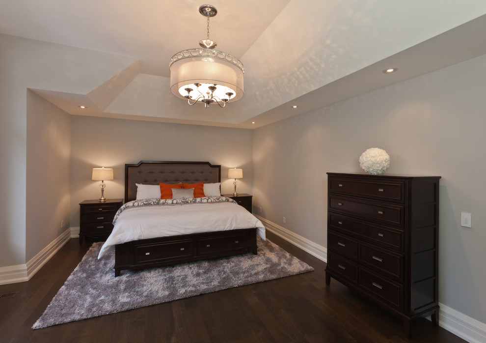 На фото: хозяйская спальня среднего размера в стиле неоклассика (современная классика) с серыми стенами и темным паркетным полом без камина с