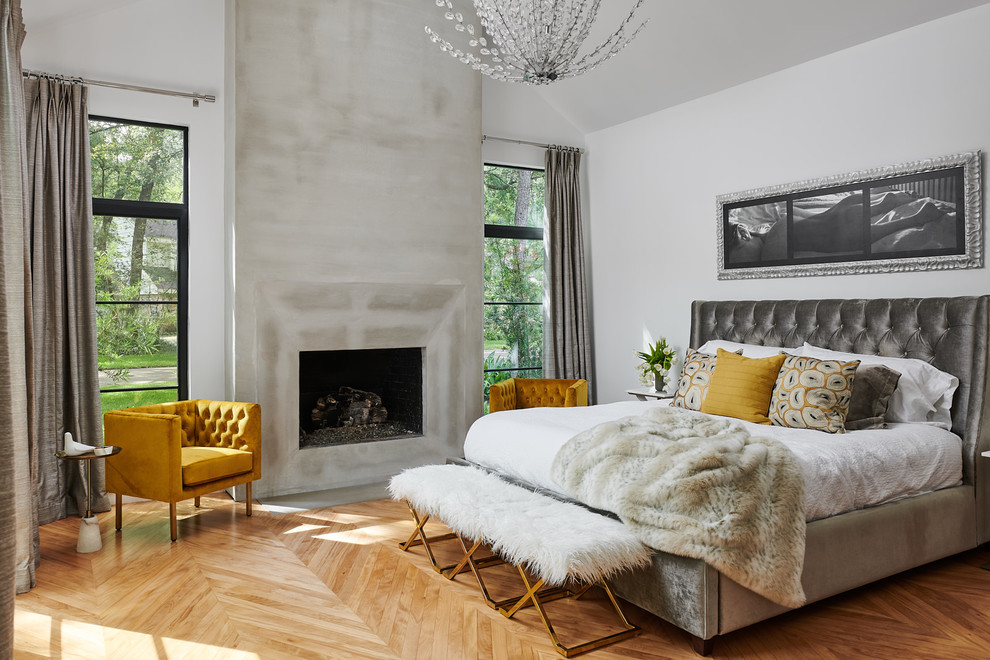 Inspiration for a mid-sized contemporary master light wood floor bedroom remodel in Houston with white walls, a standard fireplace and a plaster fireplace