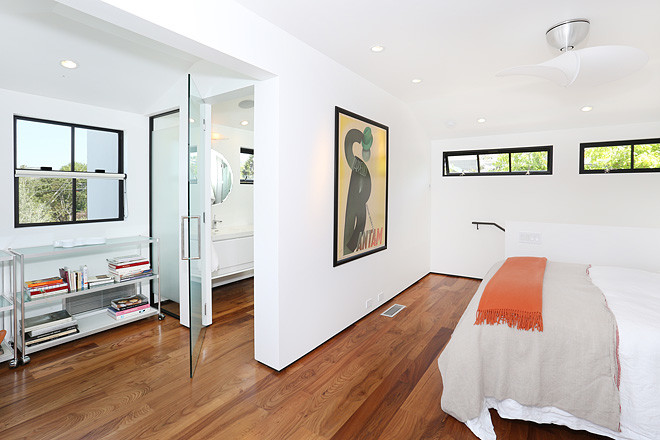 Idee per una camera matrimoniale minimalista con pareti bianche e pavimento in legno massello medio