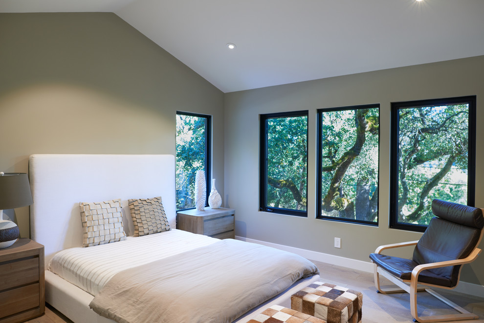 Réalisation d'une chambre d'amis design de taille moyenne avec parquet clair, un mur vert, aucune cheminée et un sol beige.