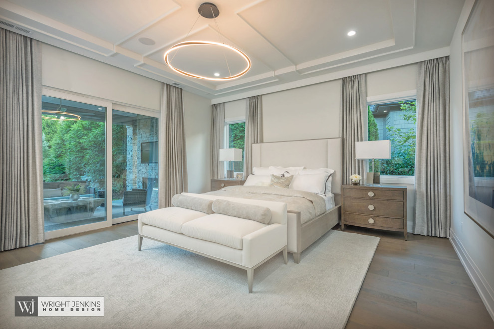 Diseño de dormitorio principal de estilo americano grande sin chimenea con paredes beige, suelo de madera en tonos medios, suelo beige y casetón