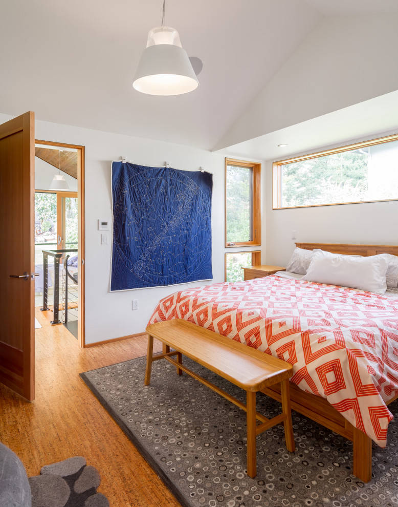Imagen de dormitorio principal contemporáneo con paredes blancas, suelo de corcho y suelo marrón