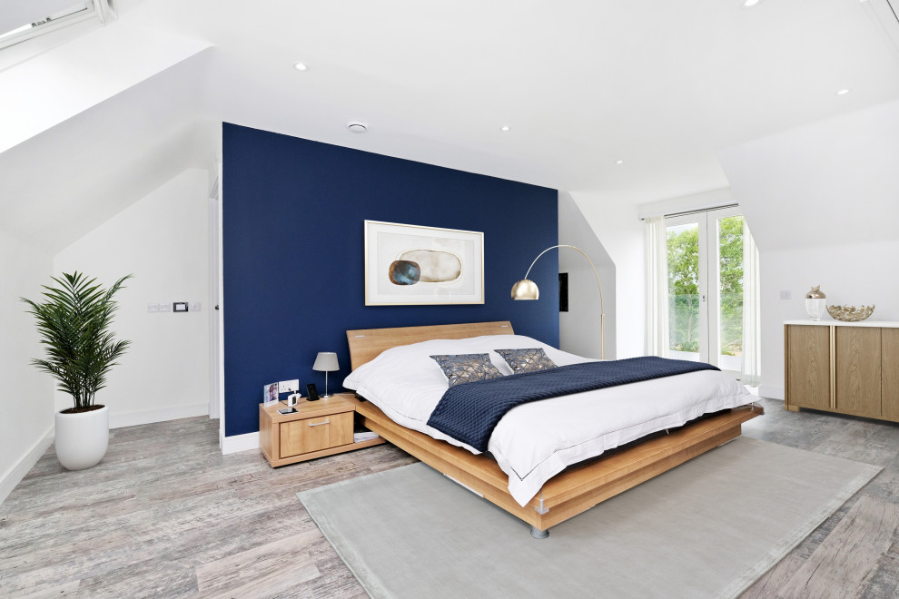Ejemplo de habitación de invitados contemporánea sin chimenea con paredes blancas, suelo de madera en tonos medios y suelo marrón